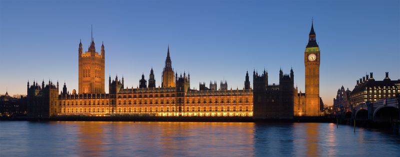 The Palace of Westminster illuminated at dusk, viewed from across the River Thames, with Victoria Tower on the left, the central spire, and the Elizabeth Tower (Big Ben) on the right