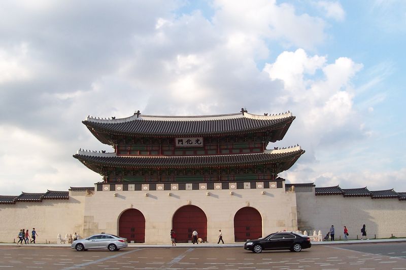 Gwanghwamun Gate, the main gate of Gyeongbokgung Palace in Seoul, viewed from Gwanghwamun Square under a partly cloudy sky