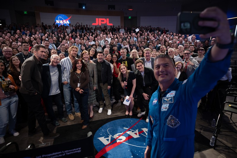 NASA astronaut Kjell Lindgren takes a selfie with panelists and a packed audience at NASA's Jet Propulsion Laboratory during a Project Hail Mary event