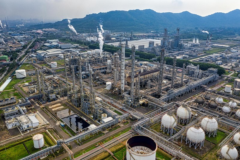 Aerial view of a large oil refinery complex with storage tanks, processing towers, and pipelines