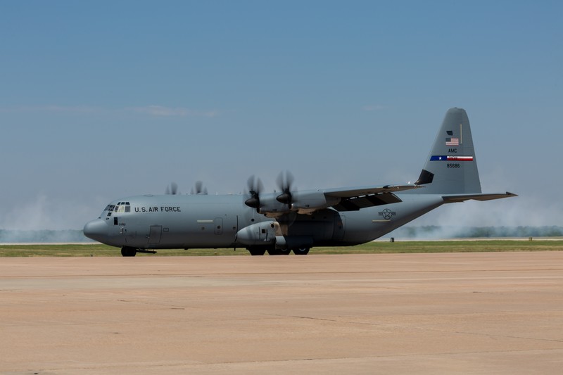 A C-130J Super Hercules military transport plane in flight against a clear sky