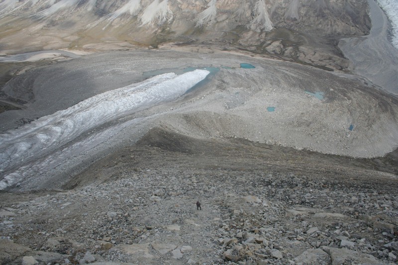 Aerial view of glacial moraine forming a natural chokepoint that constrains a river's flow through a narrow passage