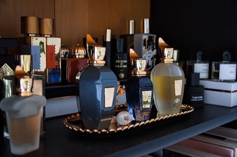 Collection of luxury perfume bottles displayed on a dark surface with warm lighting