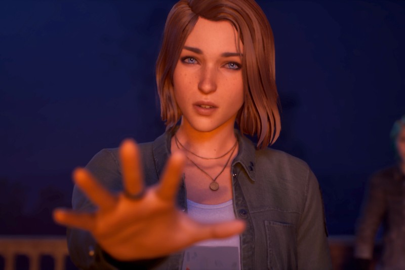 A young woman with short brown hair reaches her hand forward in a tense nighttime scene from Life is Strange: Reunion