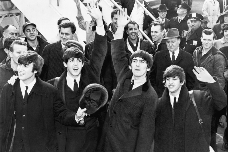 The Beatles wave to fans upon arrival at Kennedy Airport in the 1960s