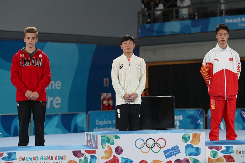 Athletes stand on a podium with Olympic rings during a medal ceremony at the Buenos Aires 2018 Youth Olympic Games