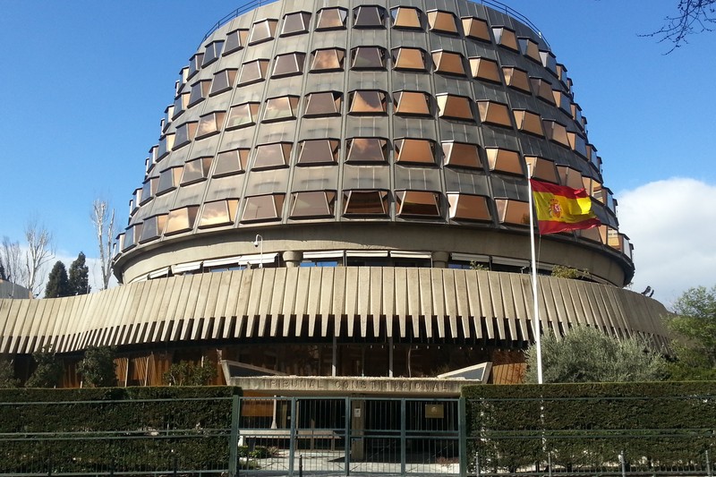 The Spanish Constitutional Court building in Madrid with a distinctive domed structure and Spanish flag