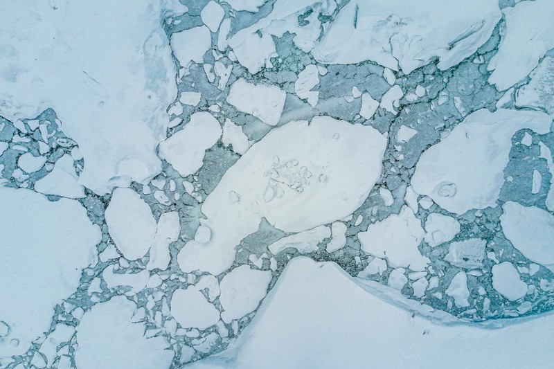 Aerial view of fragmented Arctic sea ice floes surrounded by open blue water