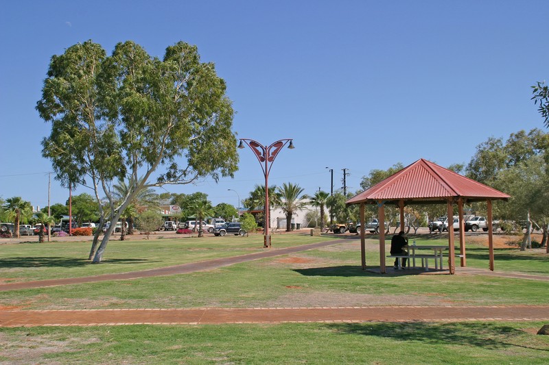 A sunny park with a red-roofed gazebo and trees in the small coastal town of Exmouth, Western Australia
