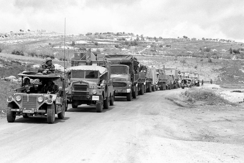Israeli military convoy traveling along a dirt road in hilly terrain in Lebanon
