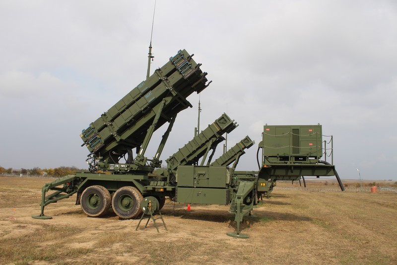 A Patriot surface-to-air missile battery deployed in an open field with launchers elevated