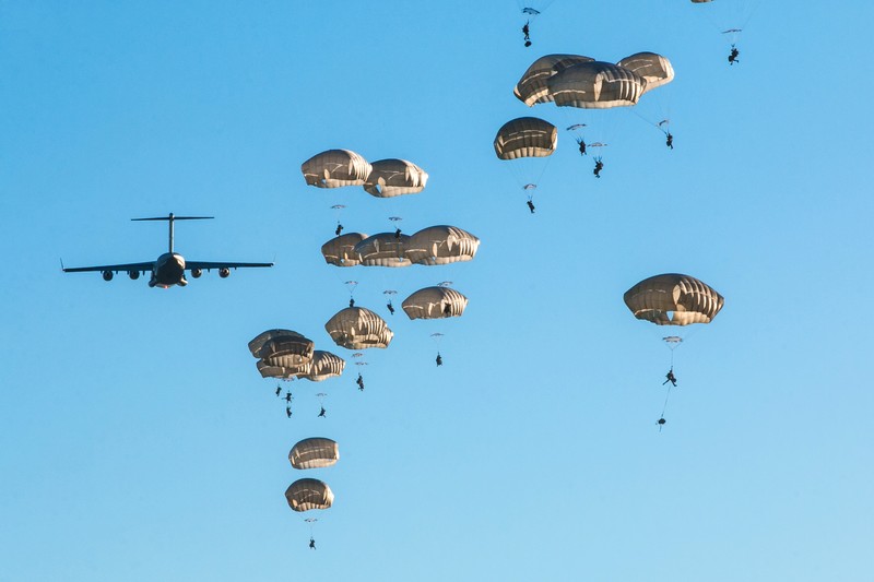 82nd Airborne Division paratroopers parachute from a C-17 Globemaster III military transport aircraft during a training exercise