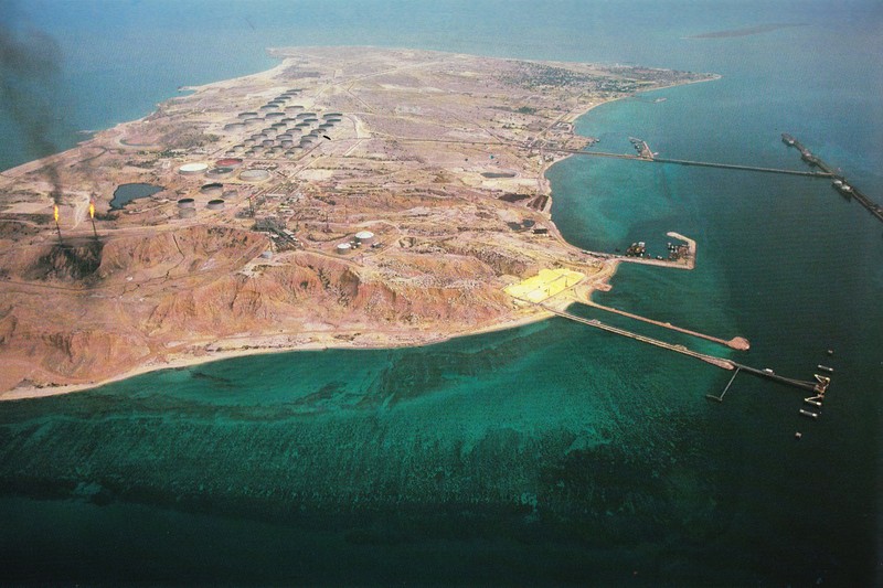 Aerial view of Kharg Island, Iran, showing oil storage tanks, pipelines, and port facilities along the coast