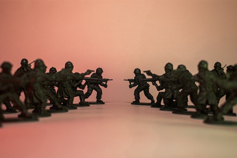 Plastic toy soldiers arranged in two opposing lines facing each other in a standoff