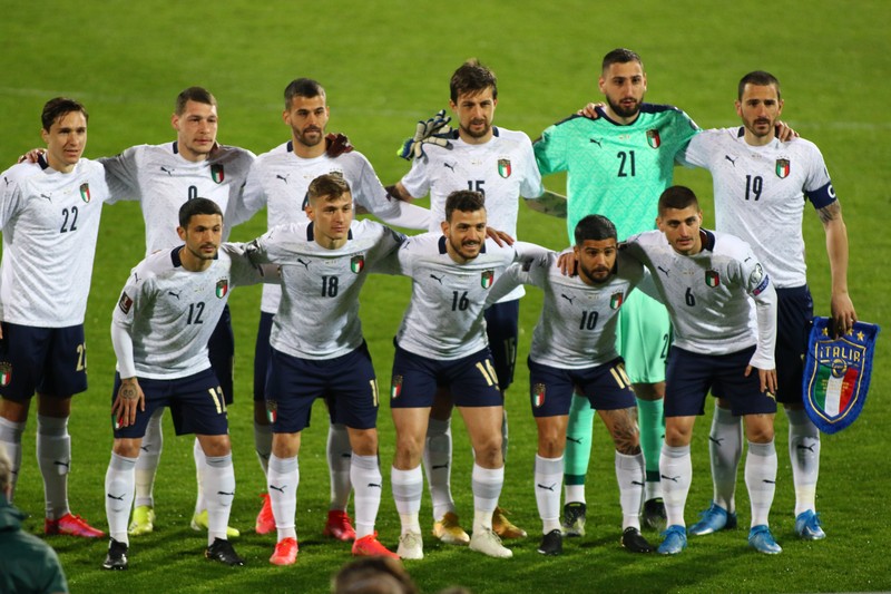 Italian national football team posing for a group photo on a pitch before a match