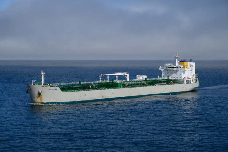 A large oil and chemical tanker navigates open ocean waters under an overcast sky