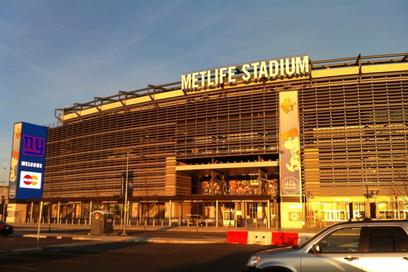 Exterior view of MetLife Stadium in East Rutherford, New Jersey, with signage visible on a clear day