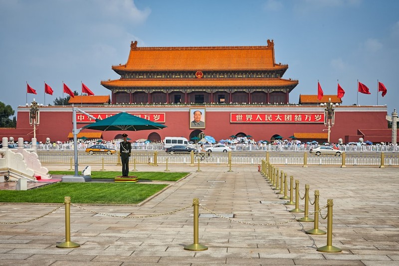 Tiananmen Gate with red flags and banners under blue sky