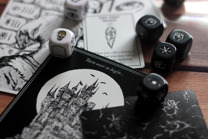 Dark tabletop RPG setup with dice and a gothic castle card on a wooden table