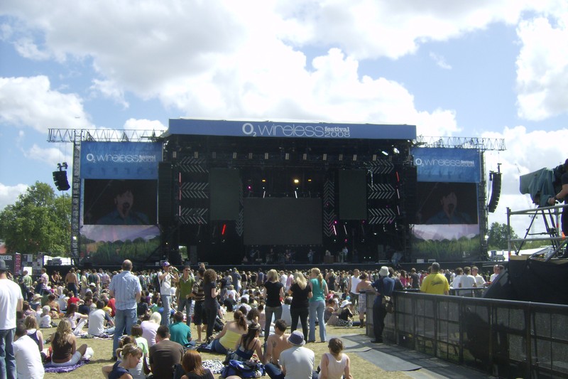 Aerial view of the main stage at the O2 Wireless Festival in Hyde Park, London, with a large crowd gathered on the grass