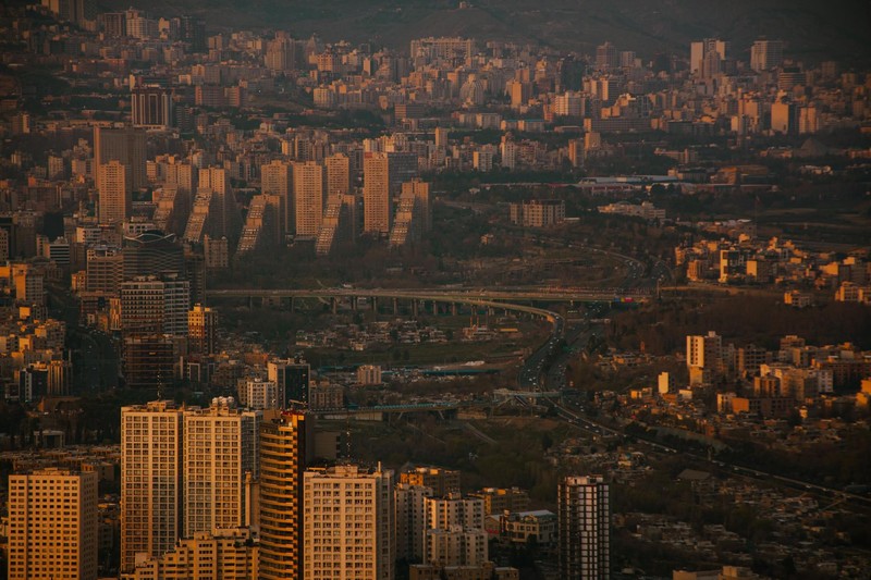 Tehran skyline at dusk with dense urban sprawl and mountains in the background