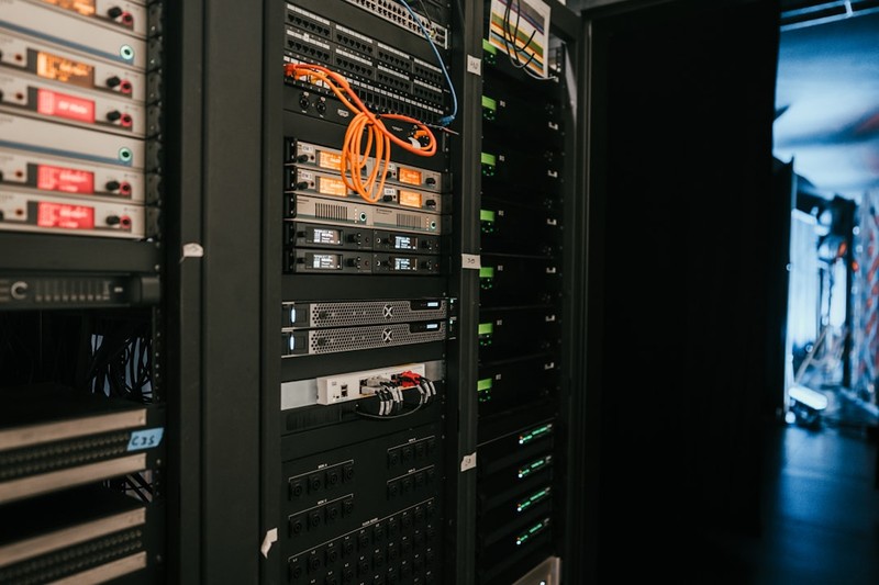 Close-up view of server racks with orange cabling in a dark data center corridor