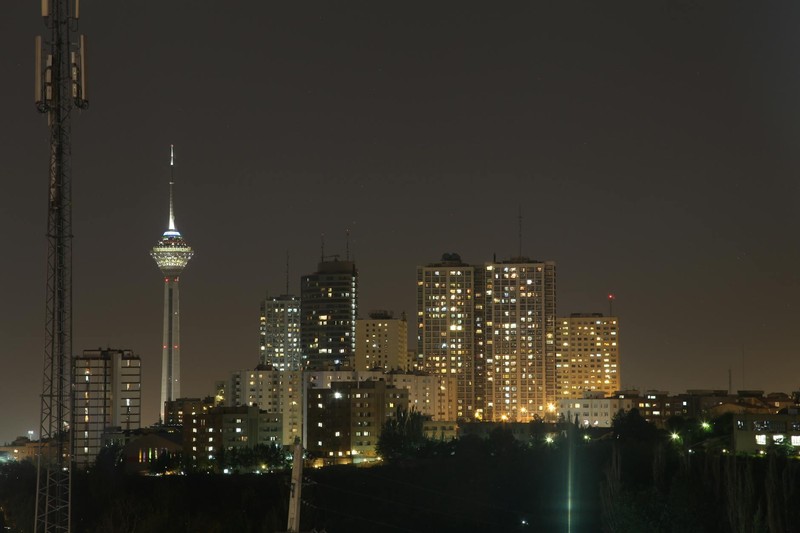 Tehran skyline at night with the iconic Milad Tower illuminated against a dark sky