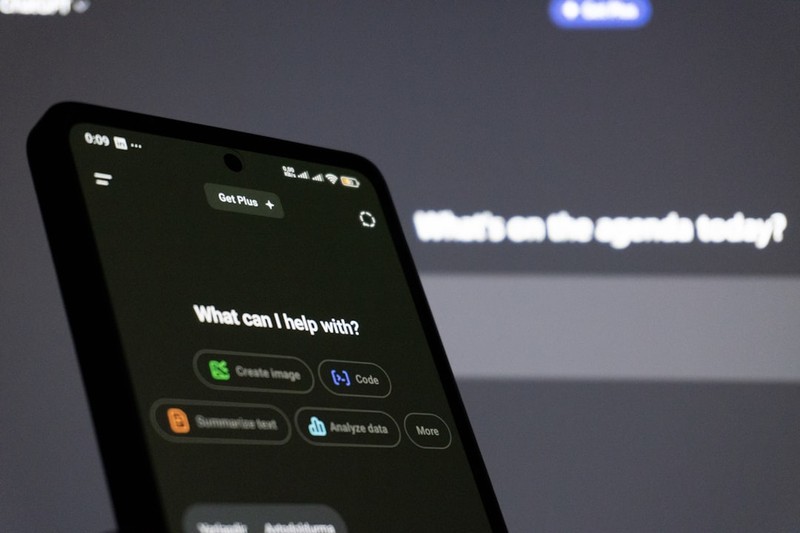 A smartphone displaying an AI assistant interface with prompt suggestions on a dark background