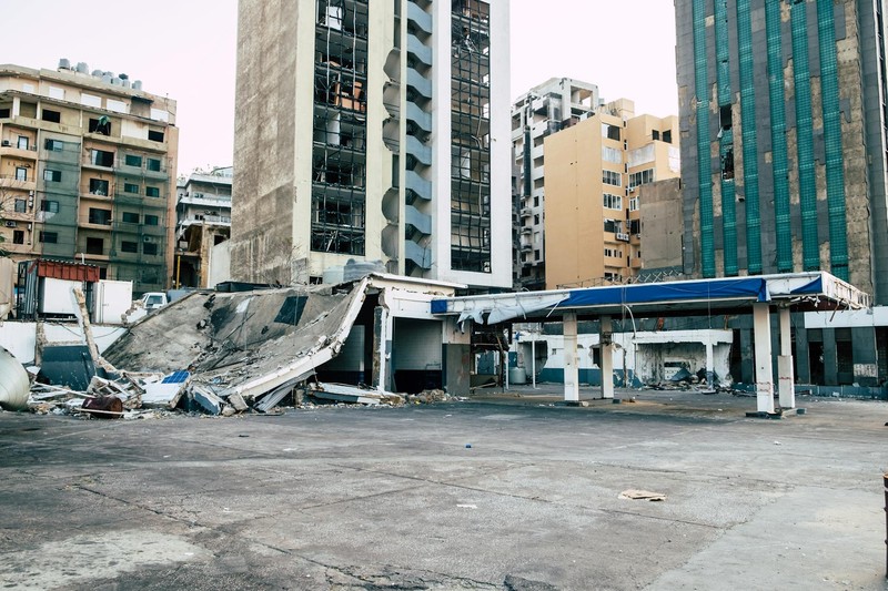 Aftermath of destruction in Beirut showing damaged buildings and debris scattered across an urban landscape