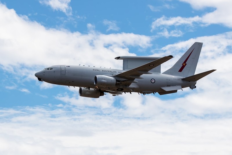 A Royal Australian Air Force E-7A Wedgetail airborne early warning and control aircraft in flight against a partly cloudy blue sky