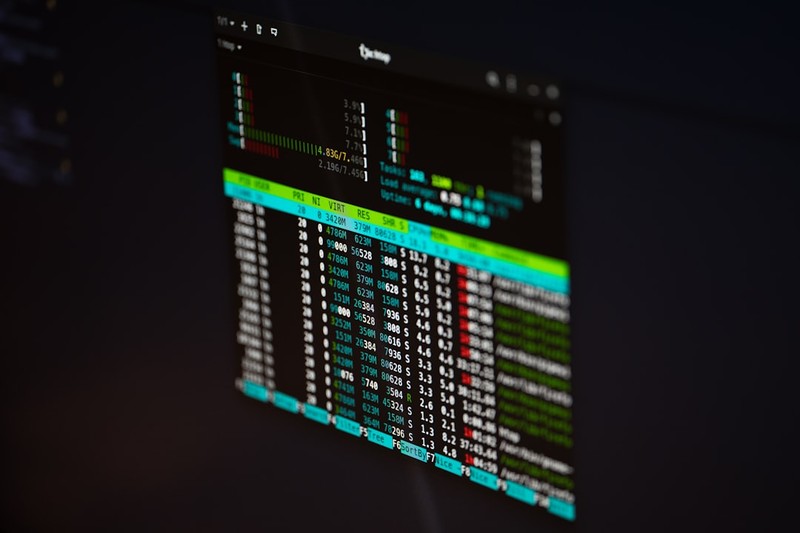 A computer screen displaying a dark-themed financial trading dashboard with color-coded market data