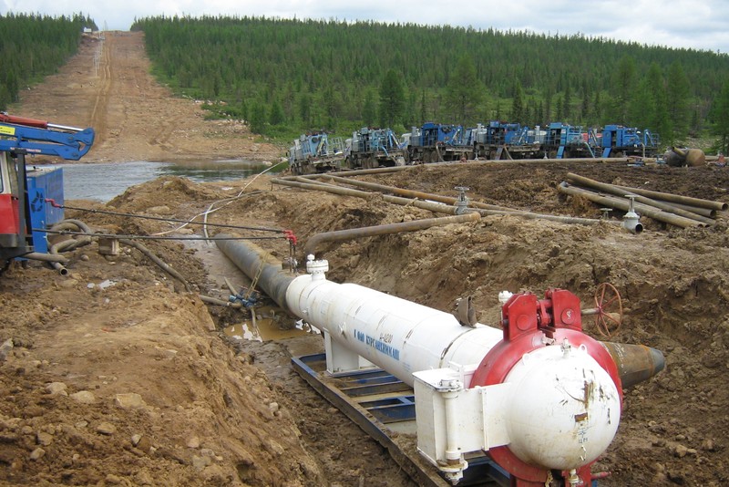 A section of the Eastern Siberia-Pacific oil pipeline running through a forested Russian landscape