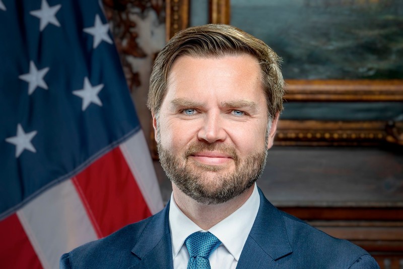 Official portrait of Vice President JD Vance in front of an American flag