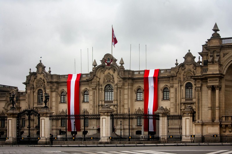 The Presidential Palace in Lima, Peru, with red and white Peruvian flags draped on the facade