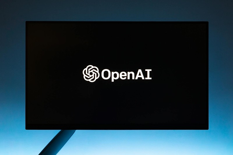 OpenAI logo displayed on a minimalist screen against a blue gradient background
