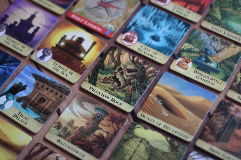 Fantasy-themed game cards spread out on a wooden tabletop