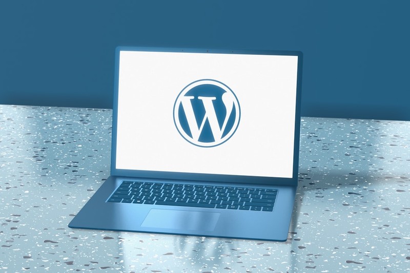 A laptop displaying the WordPress logo on its screen