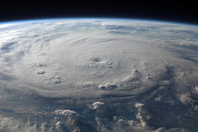 A massive tropical cyclone with a well-defined eye swirling over the ocean as seen from space