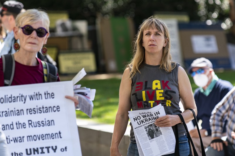 Two women at a peace rally hold signs reading 'Solidarity with the Ukrainian resistance' and 'No War in Ukraine'