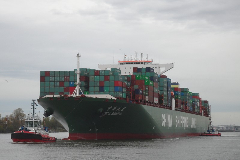 Container ship CSCL Mars from China shipping line starting port of Hamburg, front drags the harbor tug RT Margo by the shipping company Kotug
