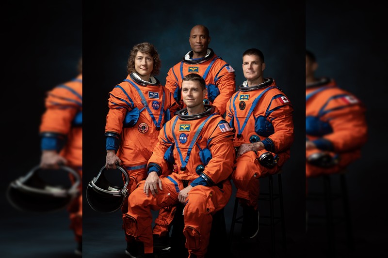The four Artemis II astronauts posing in orange flight suits in an official crew portrait