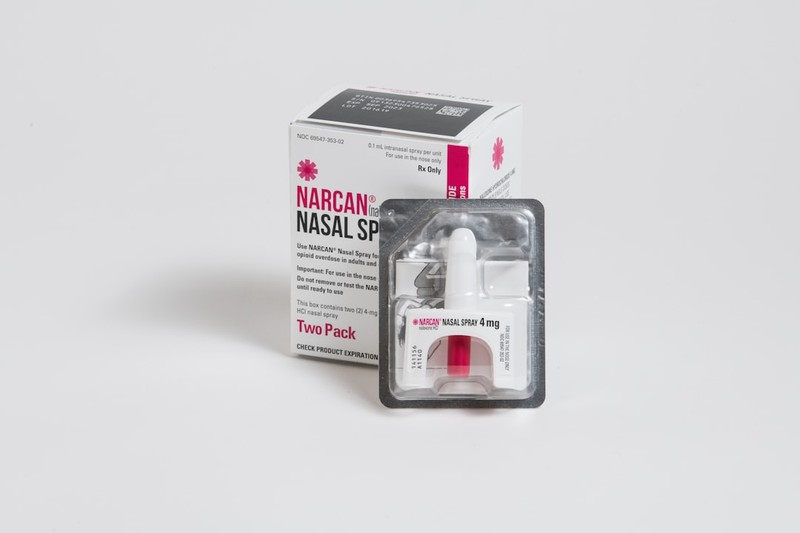 A Narcan nasal spray two-pack box and device on a plain background