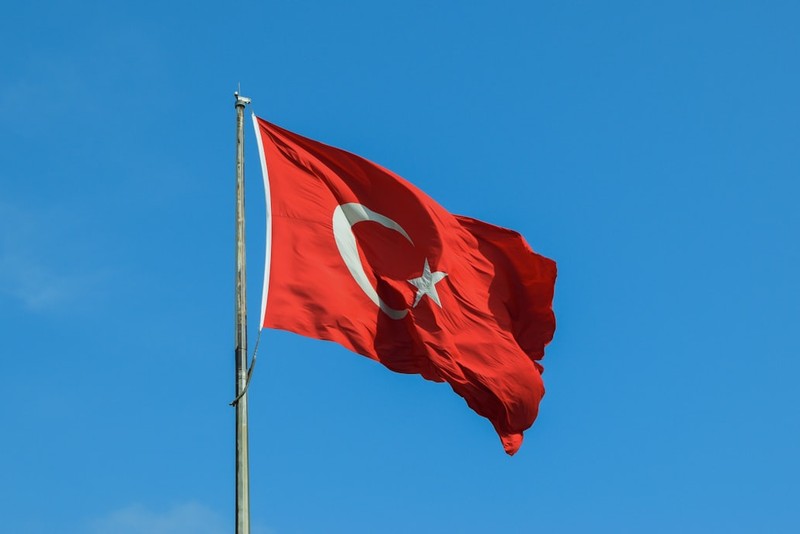 The Turkish national flag waving against a clear blue sky