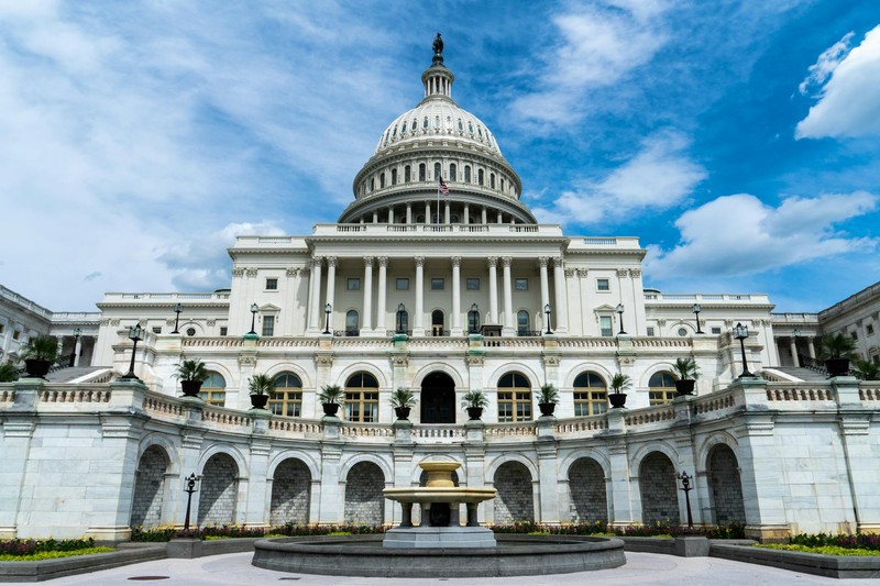 The United States Capitol Building in Washington, D.C., viewed from the east front on a sunny day with a clear blue sky