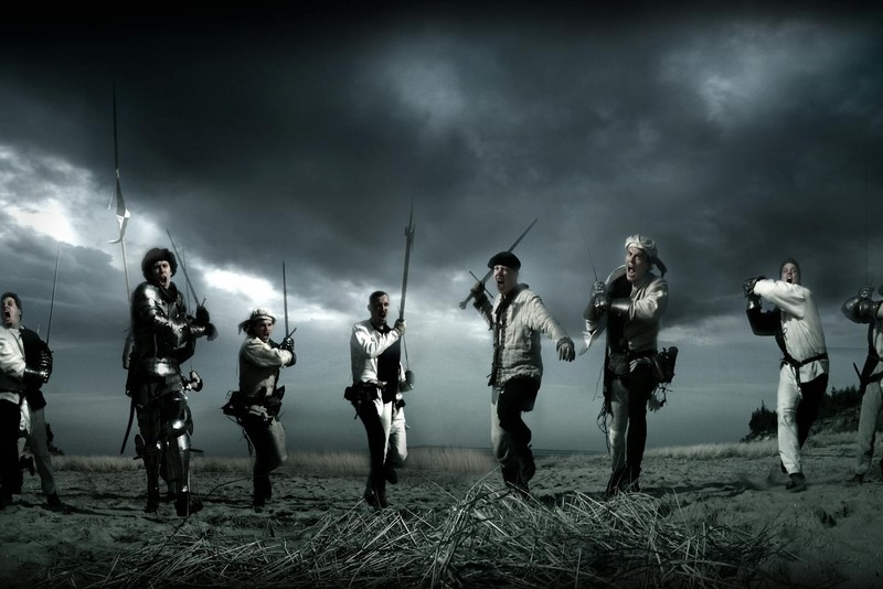 Medieval knights charging across a battlefield under stormy skies