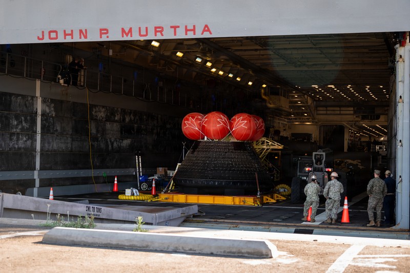 The Orion crew module from NASA's Artemis II mission sits in the welldeck of the USS John P. Murtha after splashdown recovery