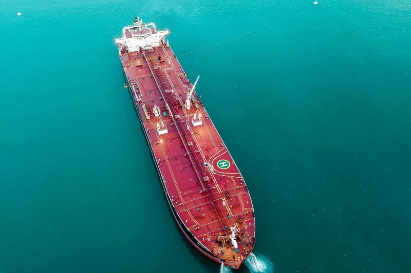 Aerial view of a large oil tanker sailing through turquoise waters