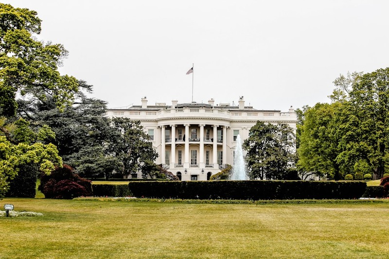 The White House viewed from the South Lawn with manicured grounds and overcast sky