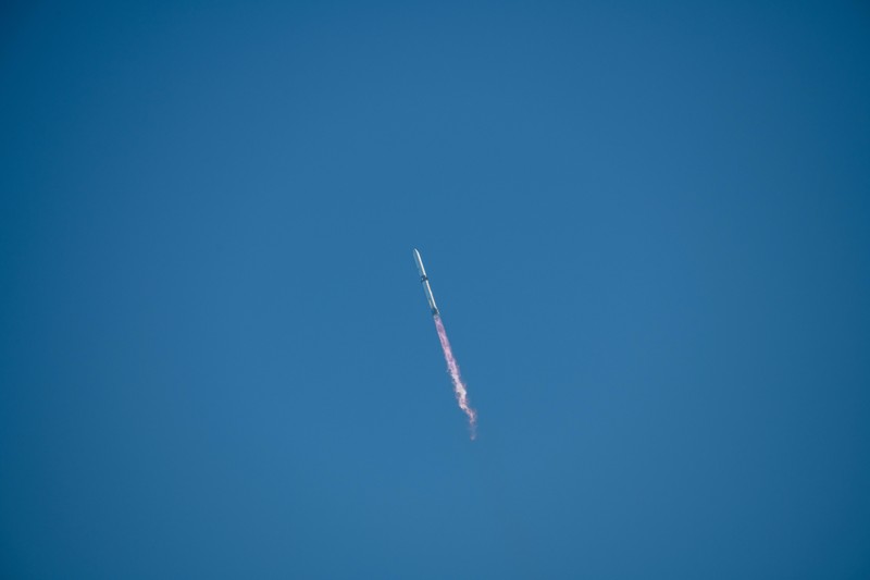 A New Glenn rocket ascends against a clear blue sky leaving an exhaust trail during launch from Cape Canaveral Space Force Station