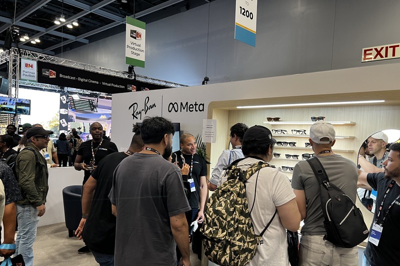 Ray-Ban Meta smart glasses display booth at a trade show with attendees examining the product